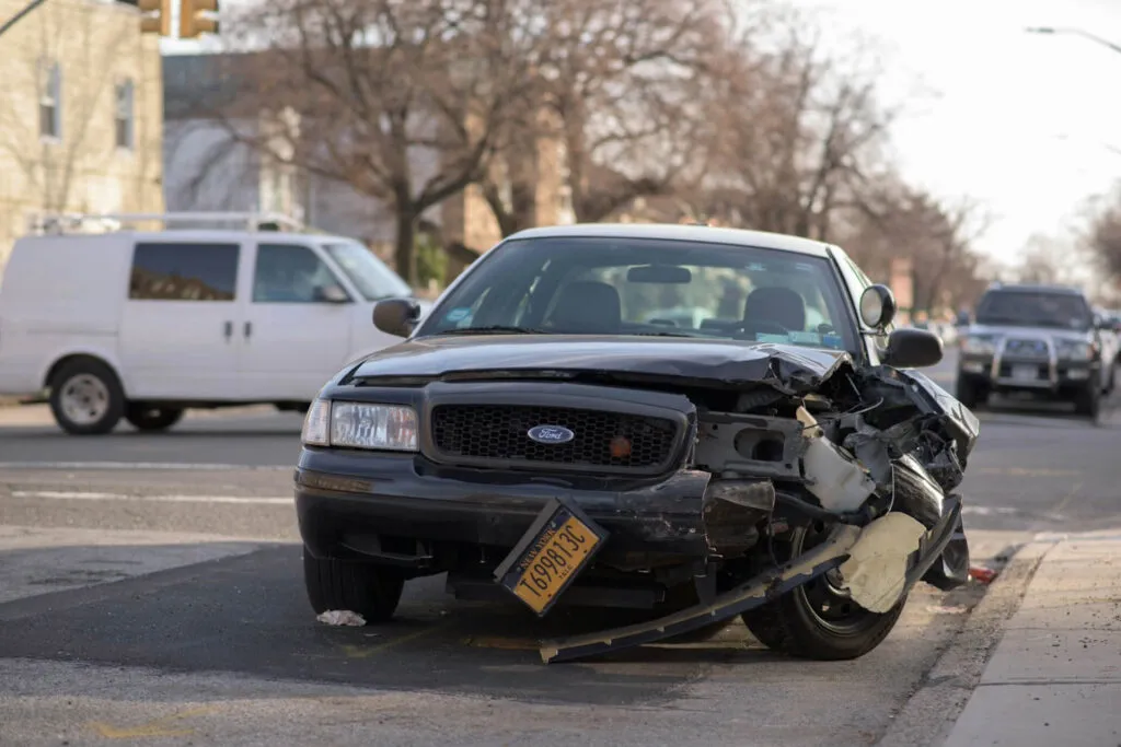 Wrecked black pickup truck on city street