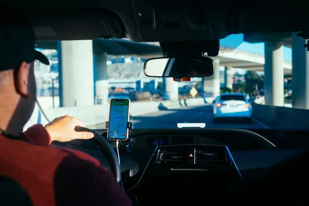 Driver using GPS navigation on smartphone in car