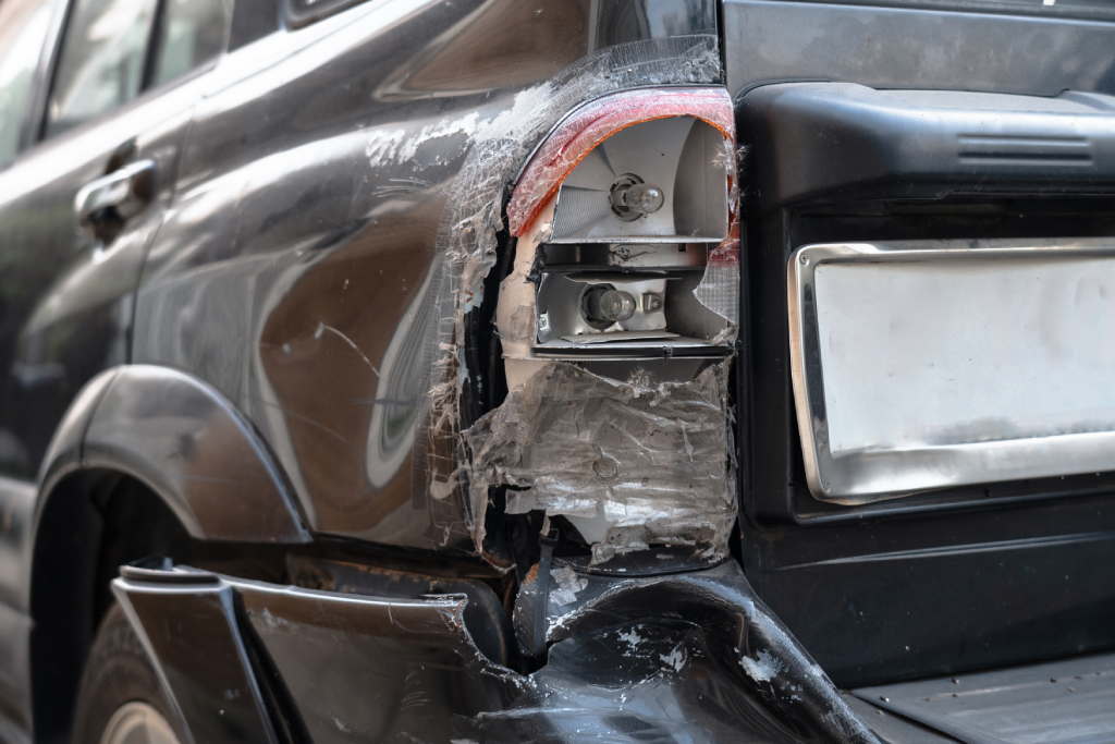 Severely damaged rear car panel and taillight.