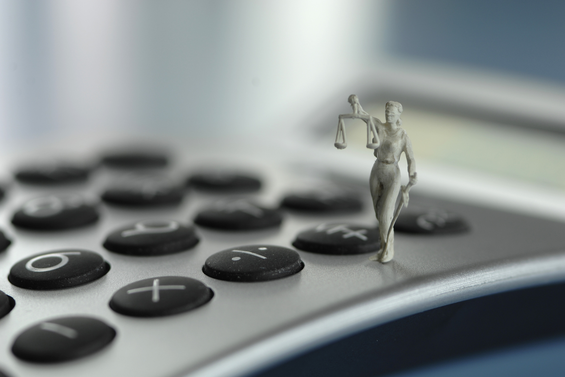 justitia figurine on calculator
