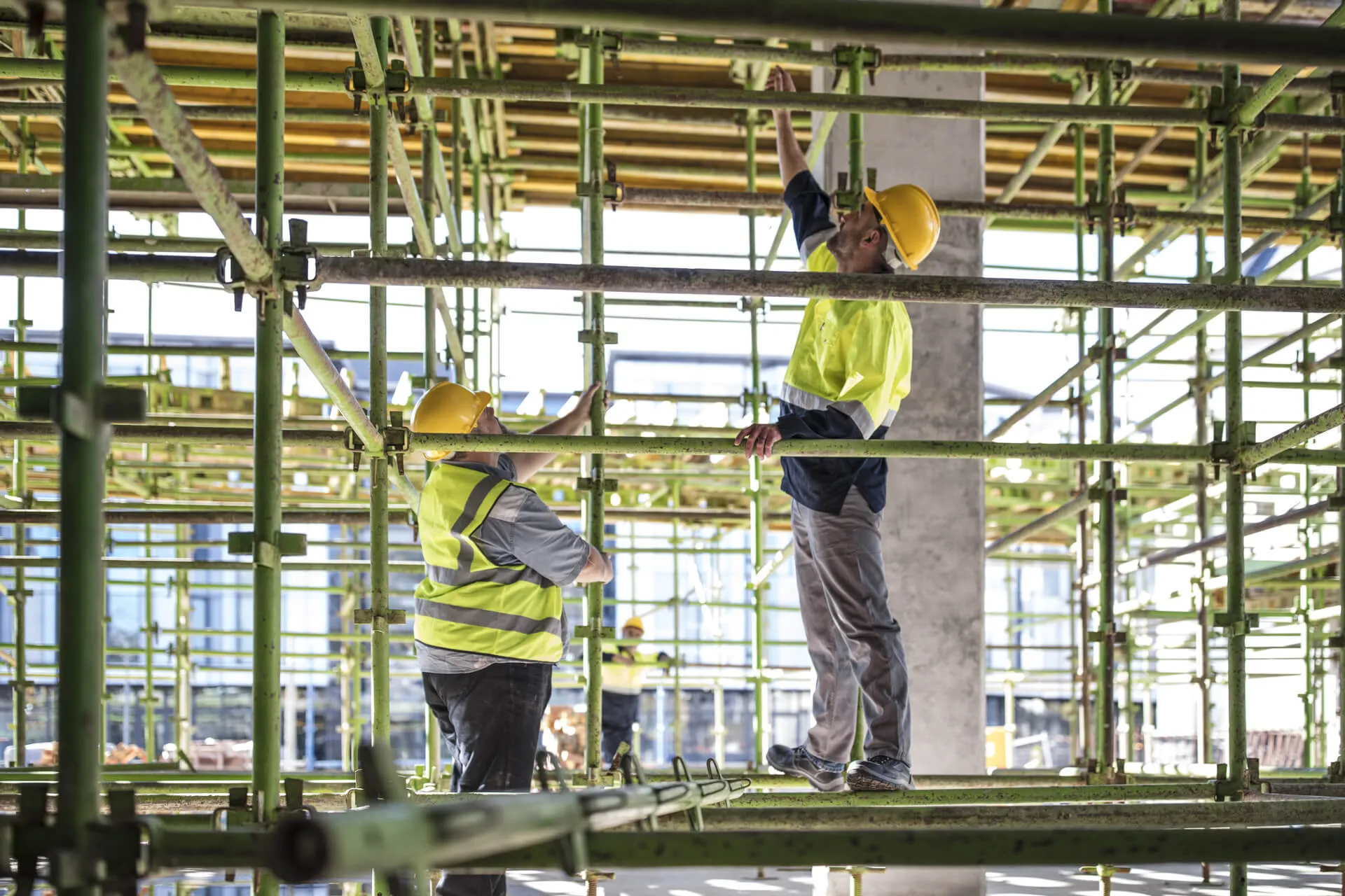 Construction workers adjusting scaffolding