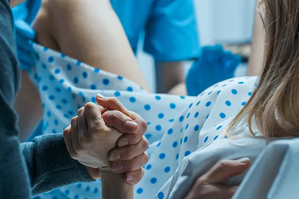 Woman in labor holding hand for support