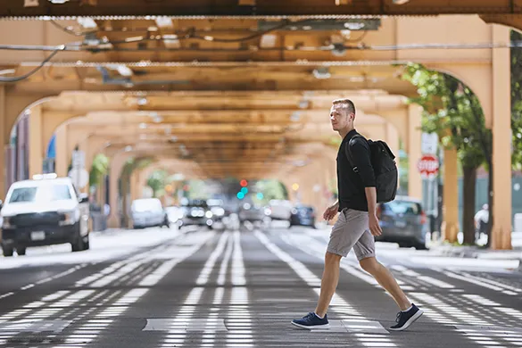 Man crossing street under bridge