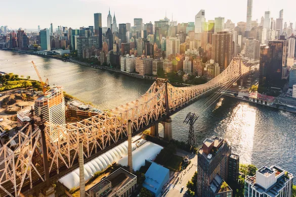 Aerial view of a large bridge leading to a city skyline.