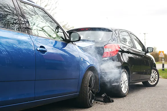 Blue car with rear damage and smoke